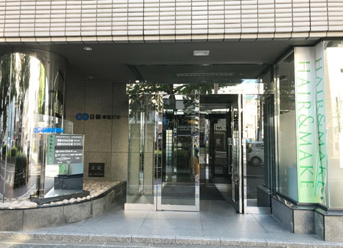 日新本社ビル玄関口です。奥へと進み、エレベーターで5階へお上がり下さい。辿り着けない等、お困りの際は、お気軽にお電話下さい。